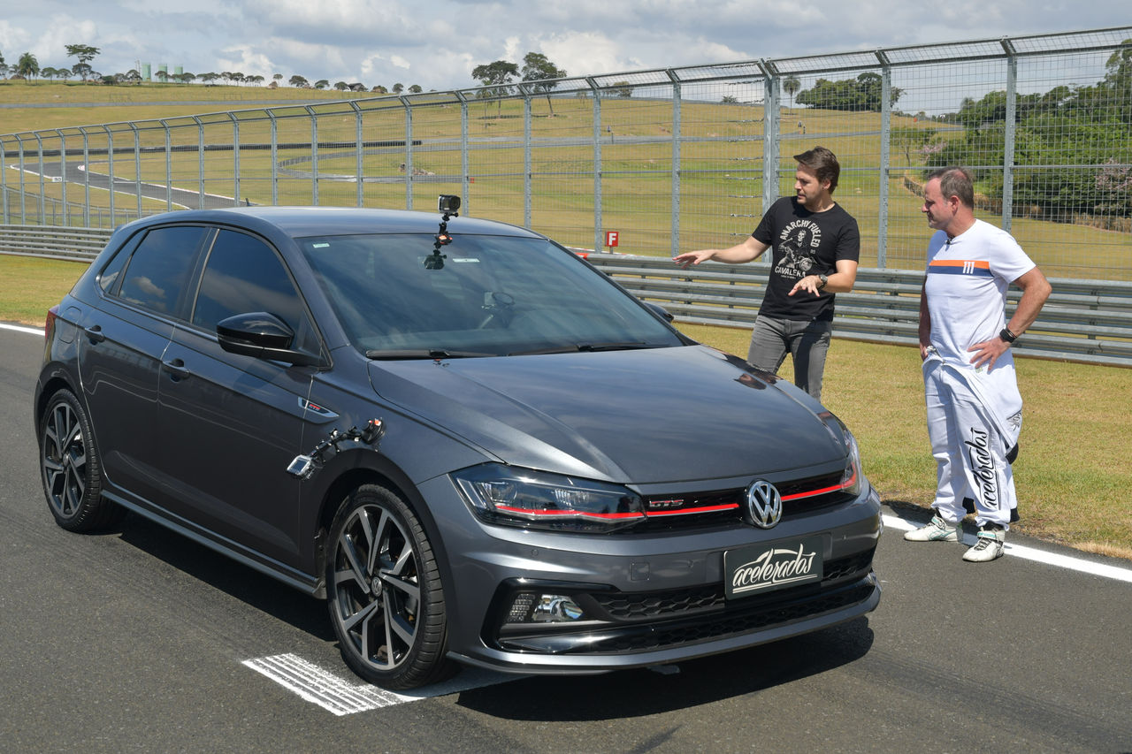 (foto do Polo durante Volta Rápida Acelerados, com Rubinho e Gerson olhando o carro)