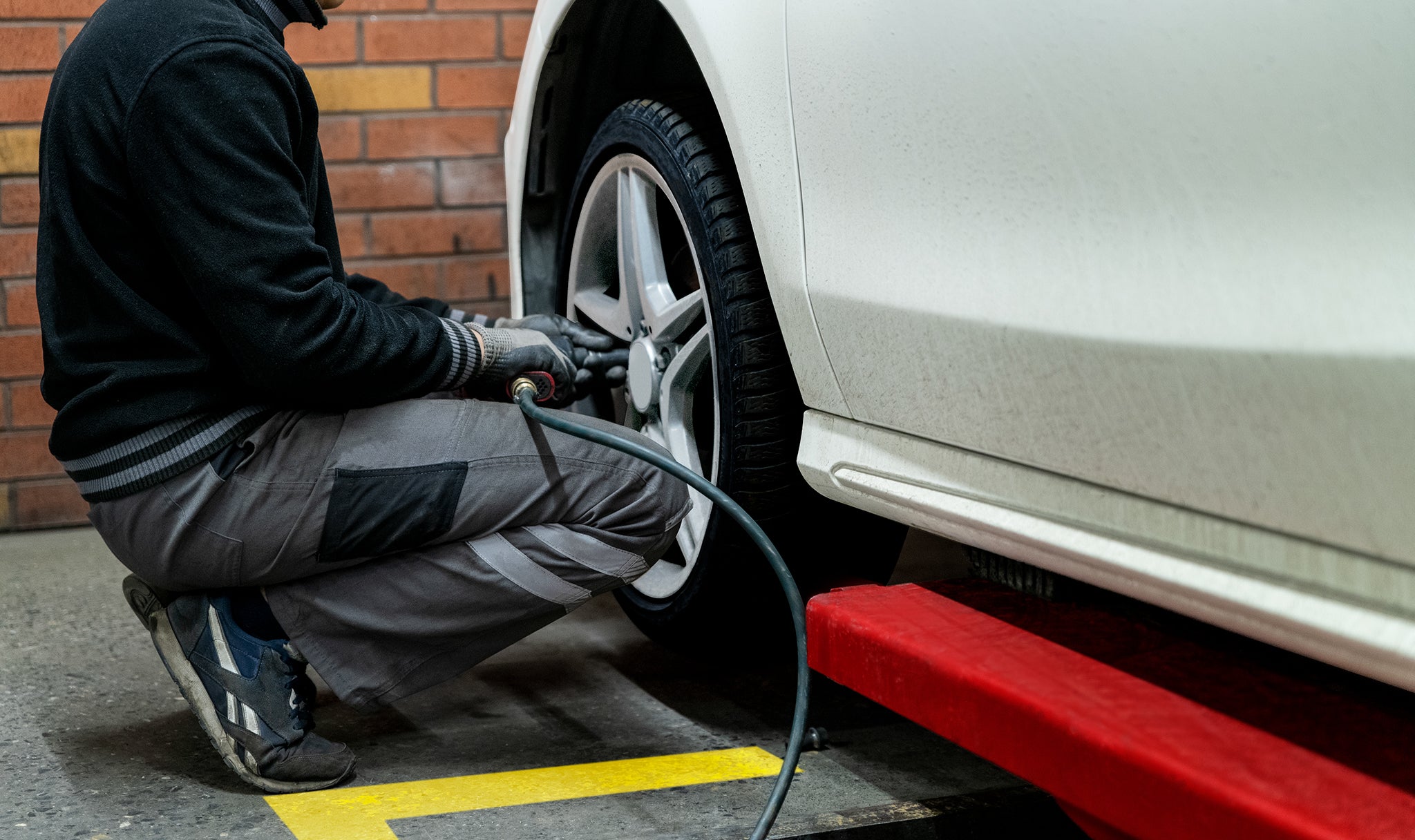 A man is tightening the screws at front tire.