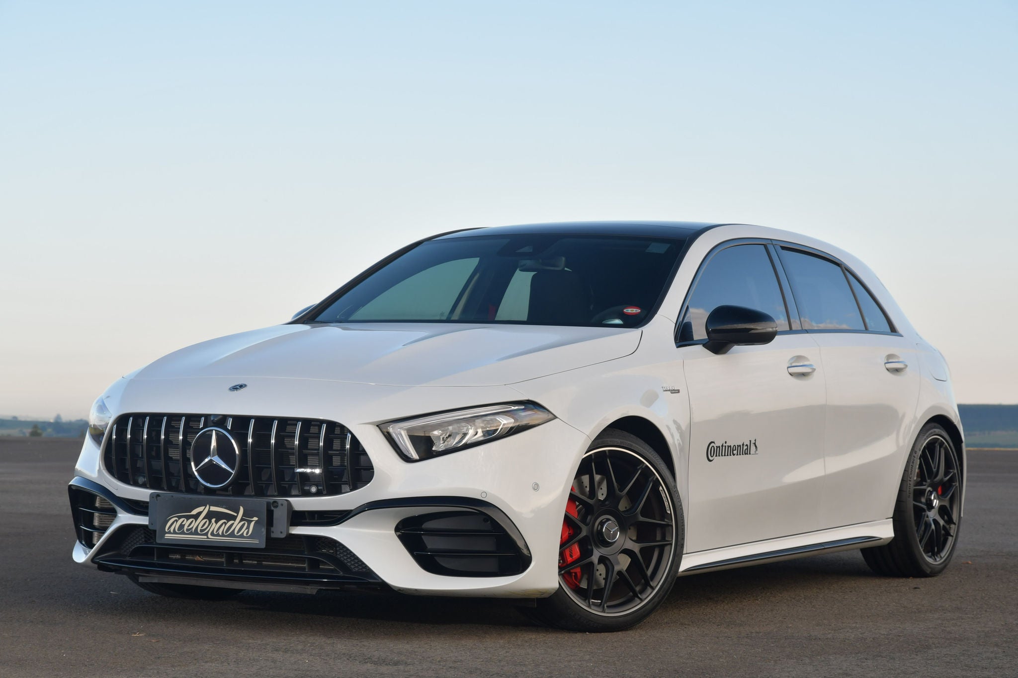 (foto lateral da frente de Mercedes AMG A45 branco com pneus Continental)