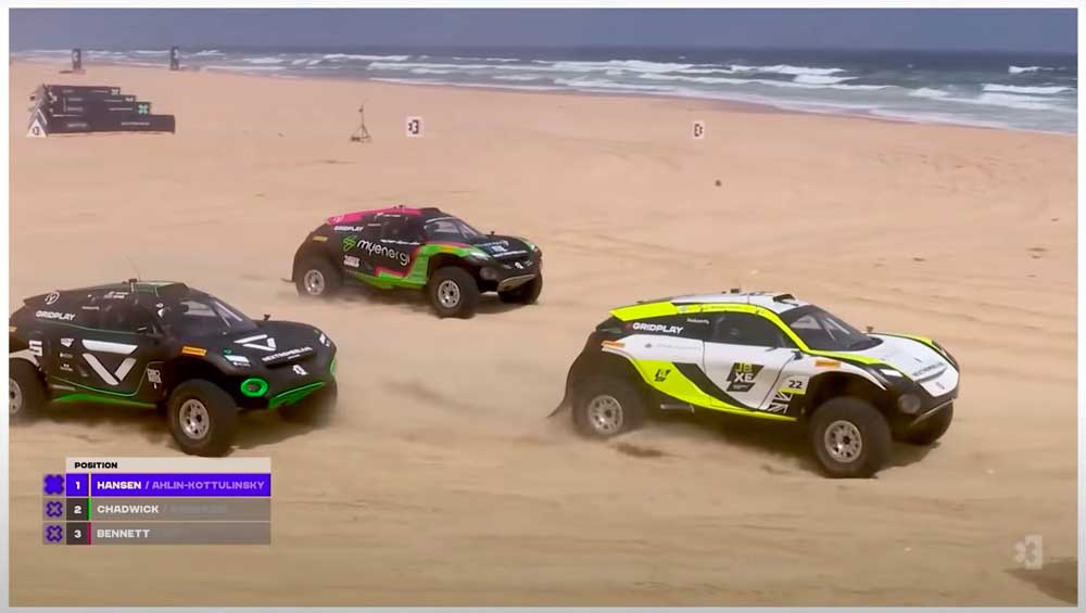 (foto de 3 SUVs do Extreme E correndo nas areias do Dakar no Senegal)