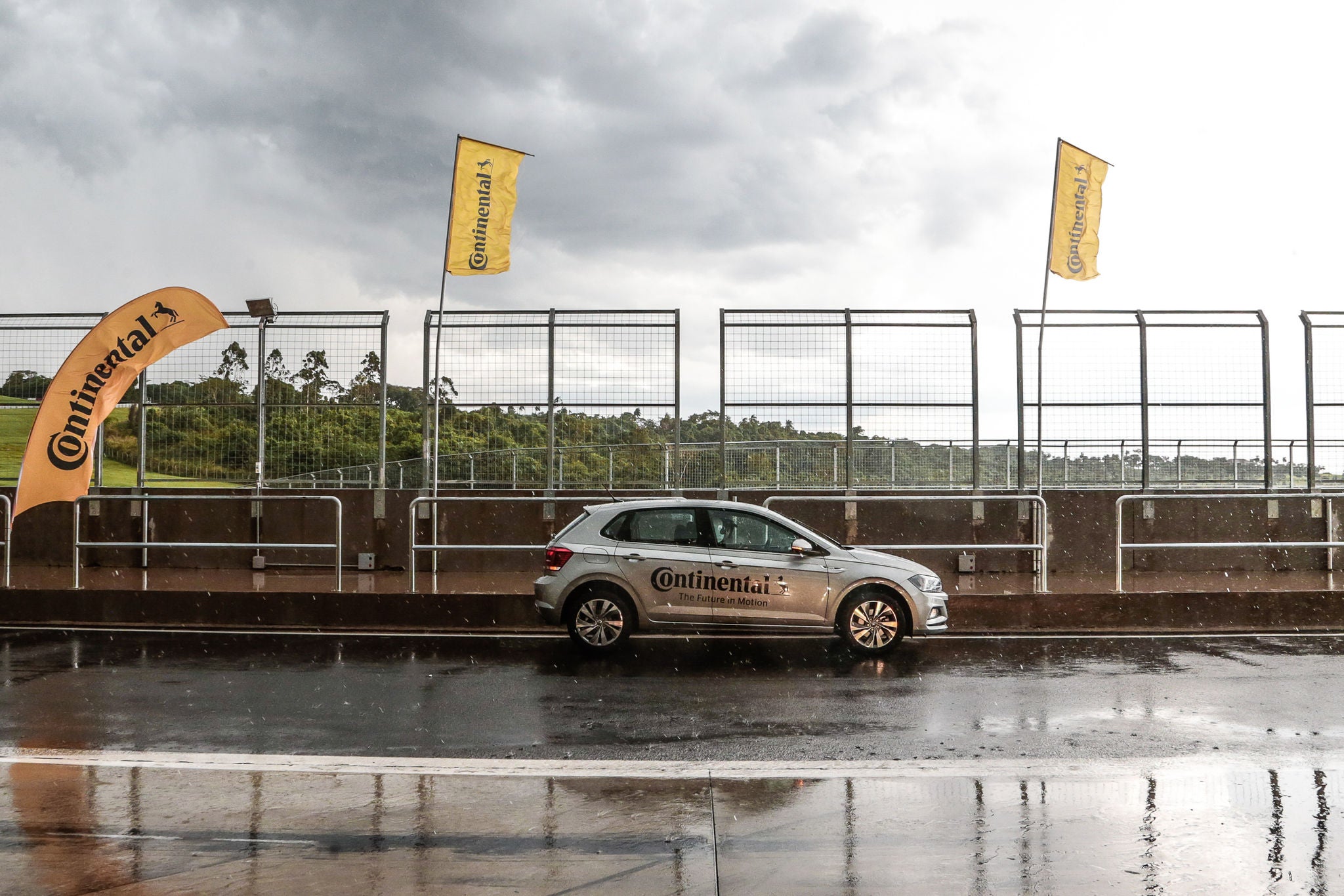 (Polo em pista de teste e bandeiras da Continental na pista)