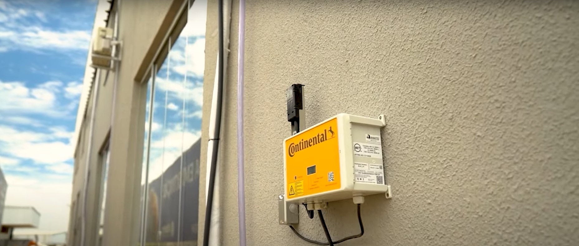 (foto da antena Conti Yard Reader instalada em parede externa bege)