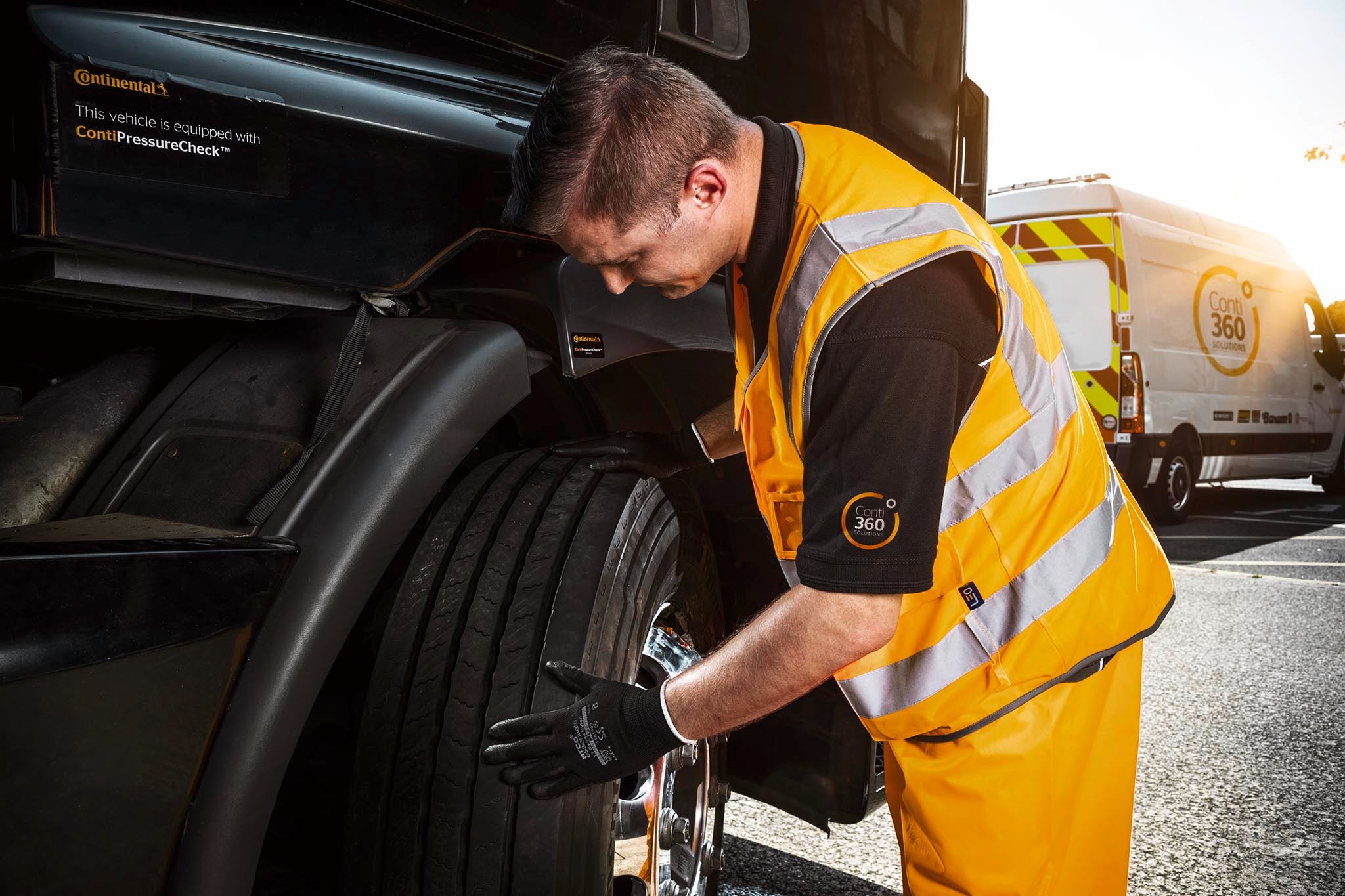 (Um homem do serviço de VAT inspeciona um pneu de caminhão)
