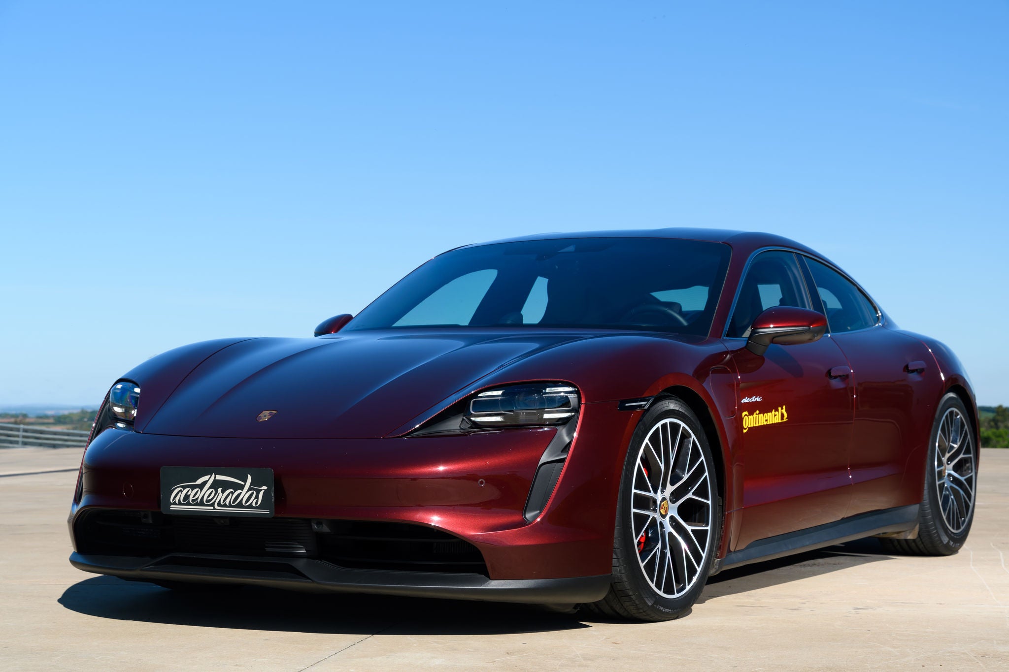 (imagem de Porsche vermelho vinho com pneus e adesivo Continental)