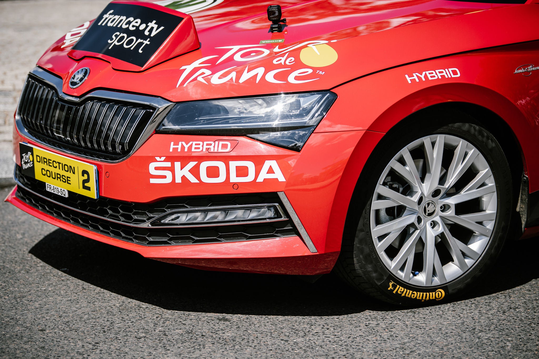 (imagem da frente do carro vermelho oficial da competição com diversos adesivos de patrocinadores, calçado com pneu da Continental)