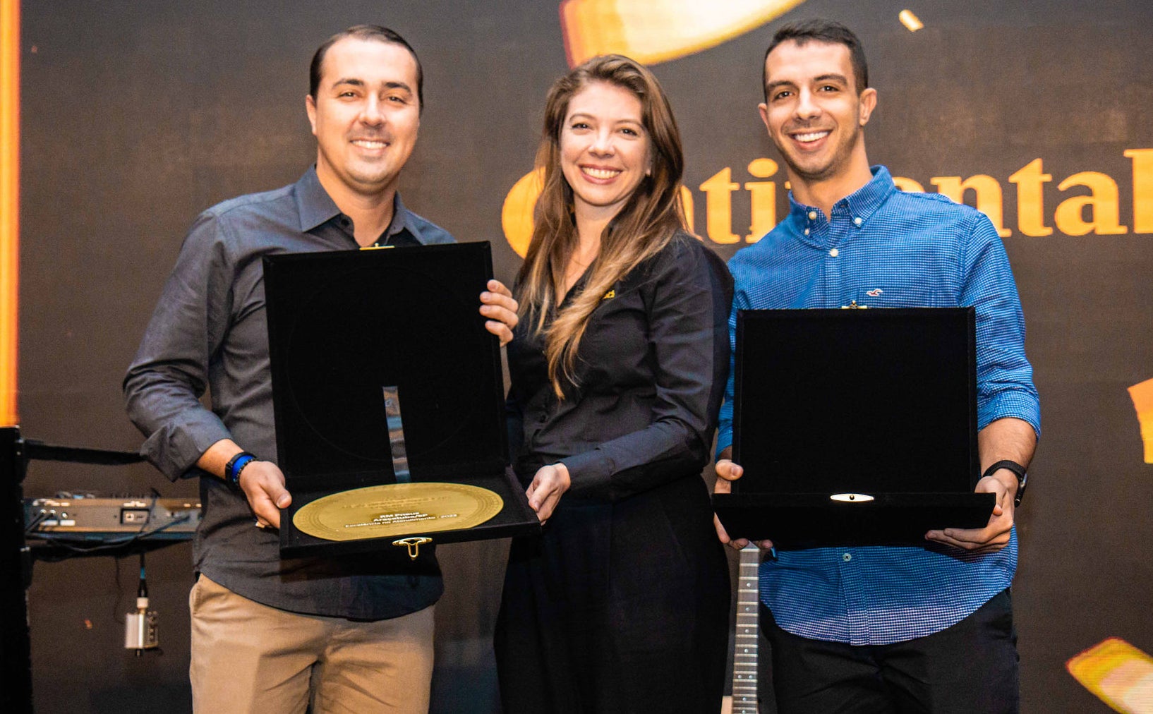 (foto de entrega do prêmio aos representantes da RM Pneus)