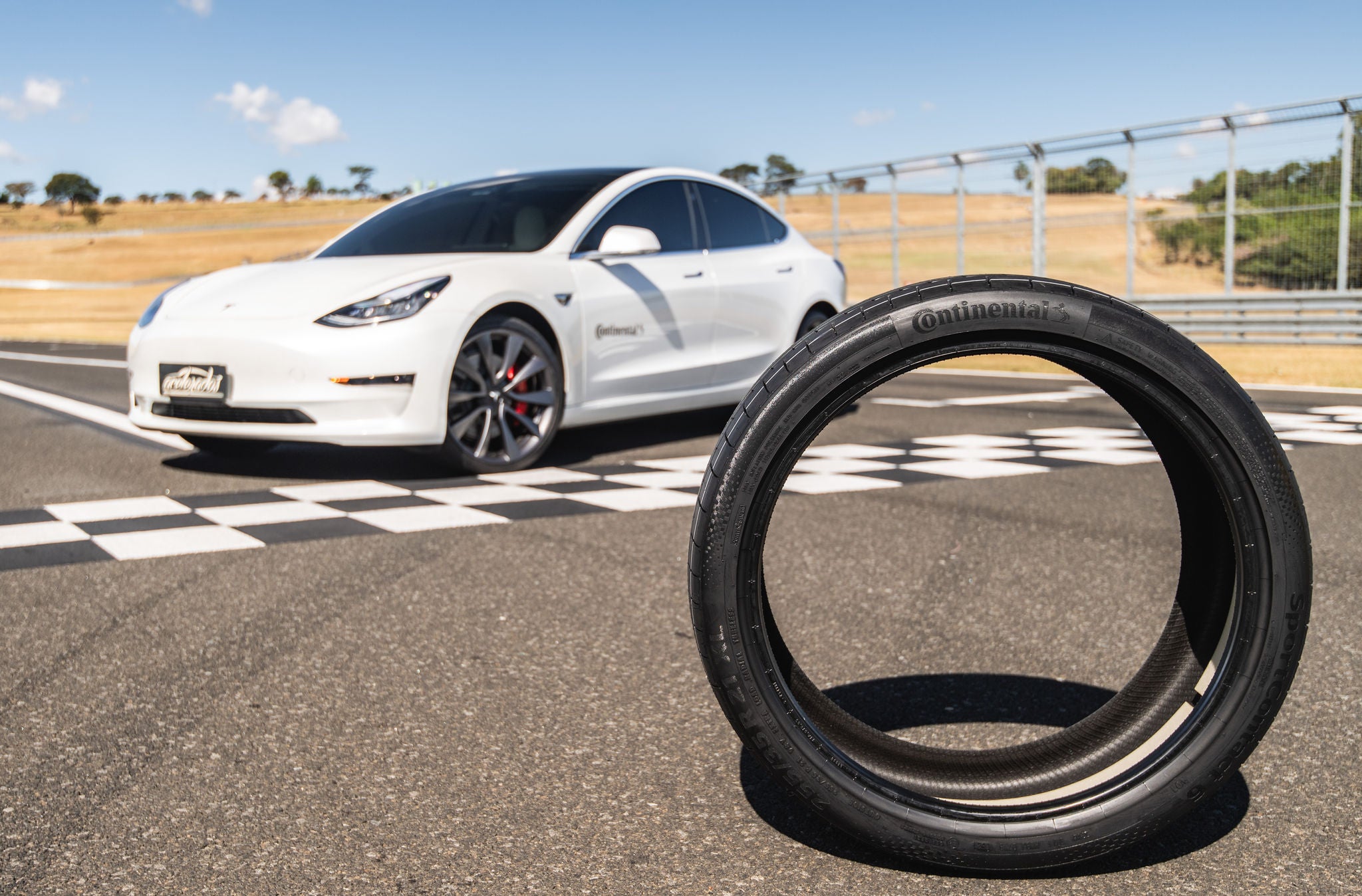 (foto do pneu Continental com tecnologia ContiSilent anti ruído e Tesla Branco ao fundo)
