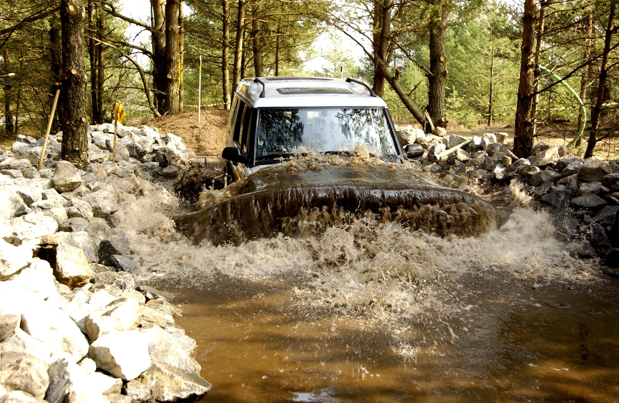 (imagem de veículo offroad passando em área alagada com lama)