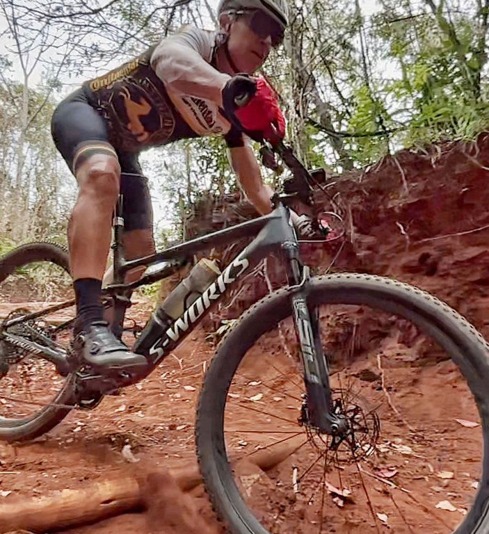 (foto de homem com roupa de ciclismo andando de bicicleta em terreno offroad)