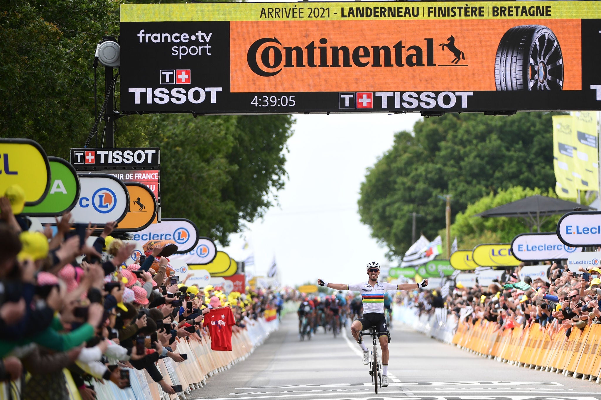 (imagem de ciclista chegando na reta final da corrida, multidão torcendo ao lado e placa da Continental no topo da chegada)