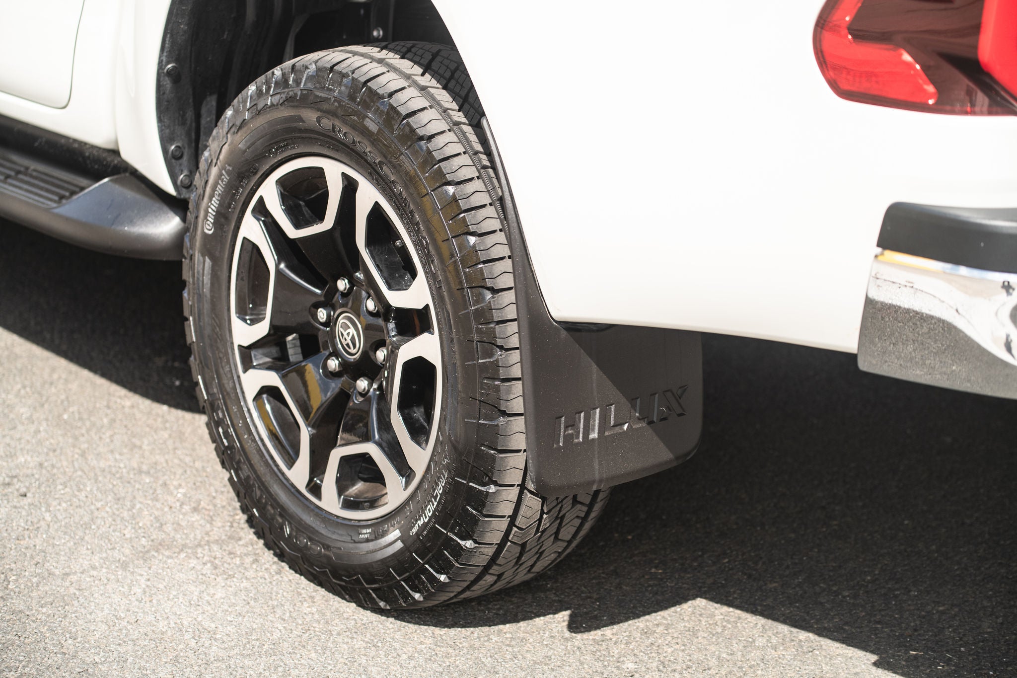 (foto traseira de caminhonete Hilux branca calçada com pneu Continental)