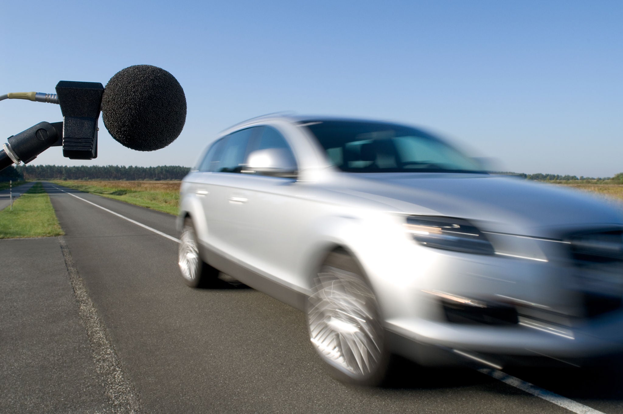 (imagem de veículo desfocada, andando em alta velocidade e passando por um microfone que está captando o ruído dos pneus)