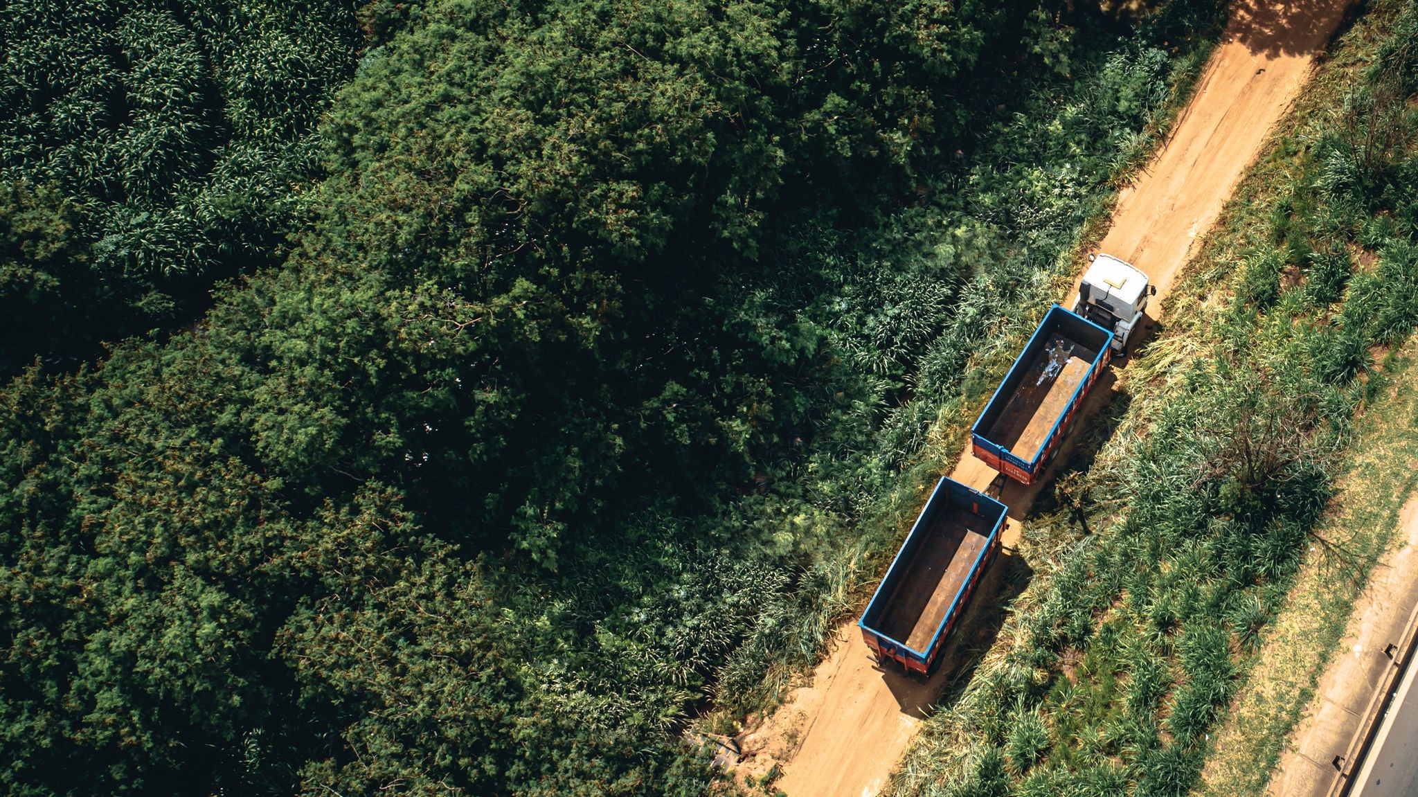 (foto aérea de caminhão bi trem vazio andando em terreno de terra) 
