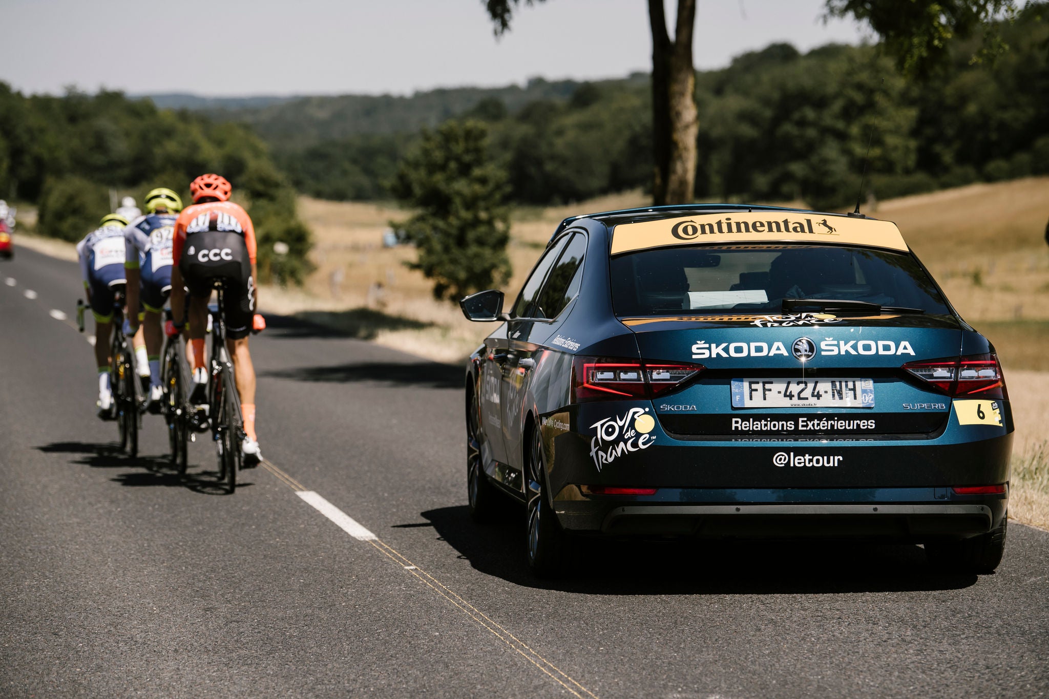 (foto de ciclistas em pista com carro de apoio adesivado com Continental)