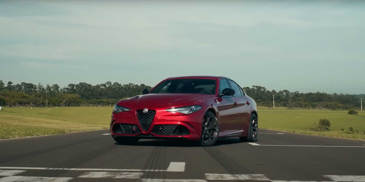 (Alfa Romeo Giulia Quadrifoglio vermelho brilhante em pista de corrida, destacando design esportivo, com linhas agressivas e aerodinâmicas. Conheça tudo sobre Alfa Romeo Giulia Quadrifoglio, incluindo ficha técnica detalhada e escolha de pneus de alta performance da Continental. Ideal para quem busca potência, precisão e estilo inconfundível.)