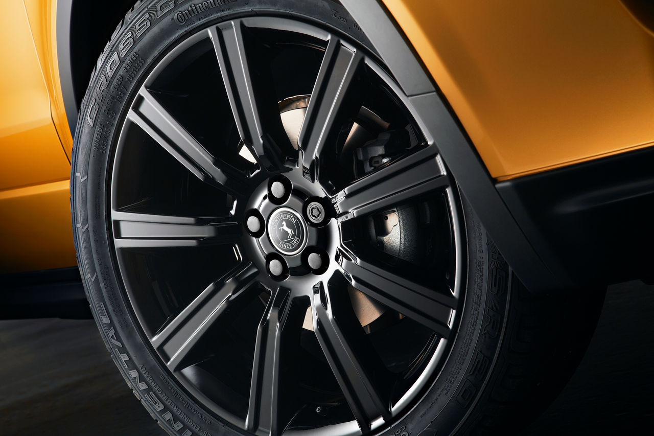 (foto em close de roda preta com pneu Continental em veículo laranja/cobre)